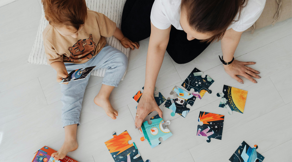 mão e filho montam puzzle