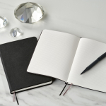 Caderno A5 de capa dura em pele sintética reciclada com dois bolsos cor preto vista de ambiente 