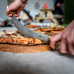 Faca para pizza e queijo Boska em aço inoxidável com dupla pega cor prateado vista de ambiente