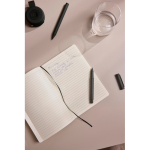 Caderno A5 de capa mole com papel reciclado, folhas pautadas cor verde vista de ambiente 3
